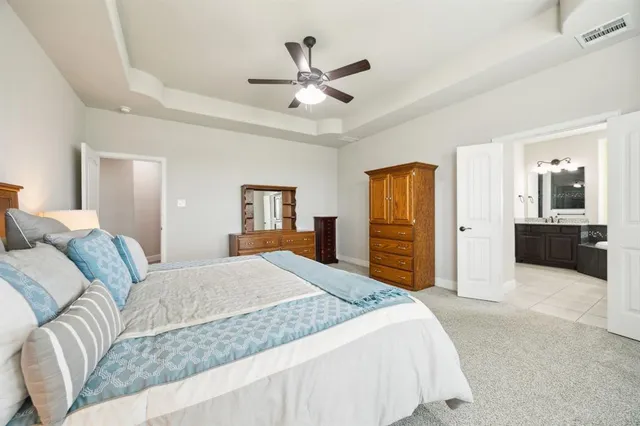 a bedroom with a large bed and a chandelier
