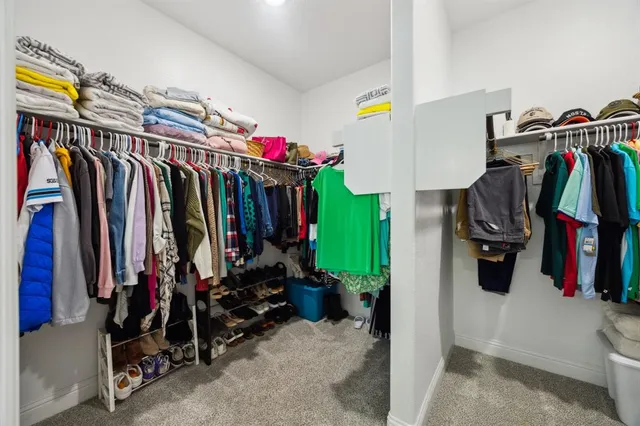 a view of walk in closet with clothes and shoes