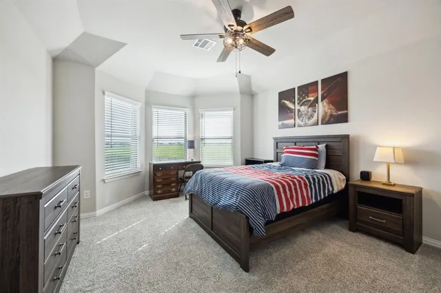 a spacious bedroom with a bed and a chandelier