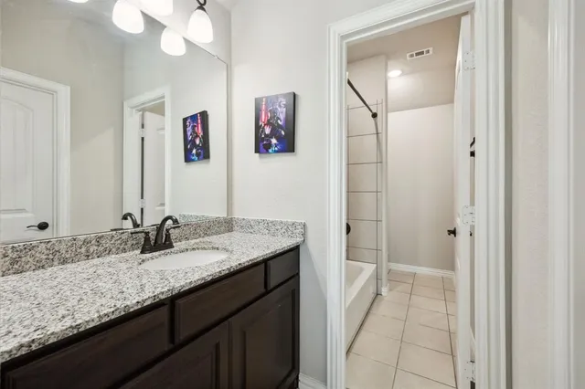 a bathroom with a granite countertop sink a mirror and a shower
