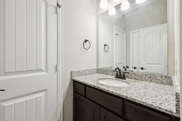 a bathroom with a granite countertop sink and a mirror