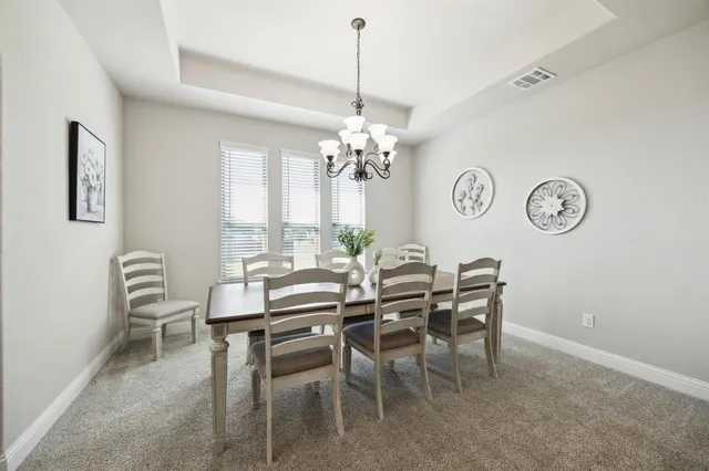 a view of a dining room with furniture and a chandelier