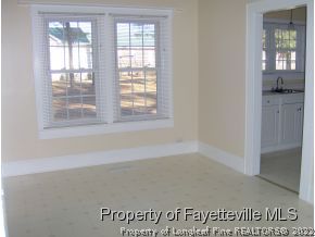 125 Reservation Road Aberdeen, NC 28315 - Photo 4 of 7 an empty room with cabinet and windows