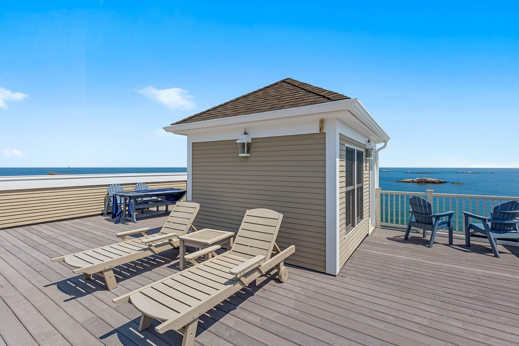 66 Glades Road, Unit 5 Scituate, MA 02066 - Photo 11 of 14 a view of a roof deck with table and chairs a barbeque with wooden floor and fence