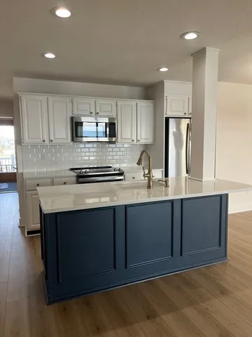 a kitchen with stainless steel appliances a sink stove and refrigerator