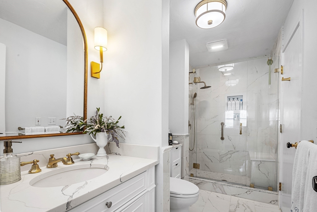 66 Glades Road, Unit 5 Scituate, MA 02066 - Photo 9 of 14 a bathroom with a granite countertop sink mirror vanity and toilet