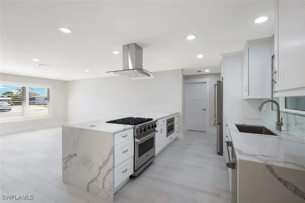 a kitchen with stainless steel appliances granite countertop a sink stove and refrigerator
