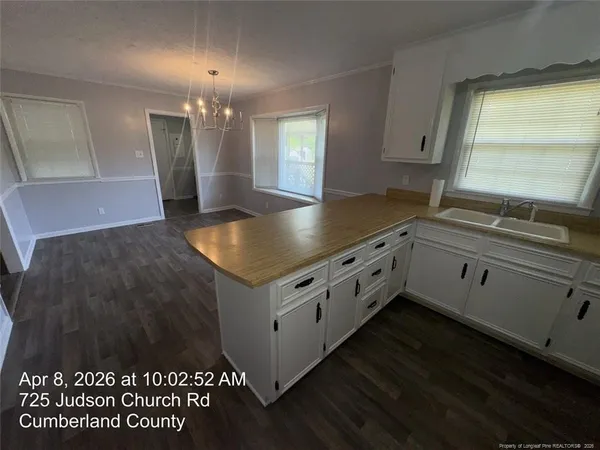 a kitchen with granite countertop a sink cabinets and wooden floor
