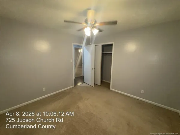 an empty room with a ceiling fan and a window