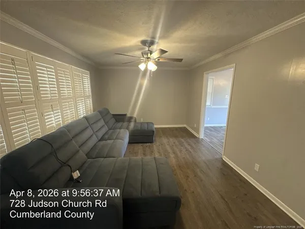 a living room with a bed furniture and a large window