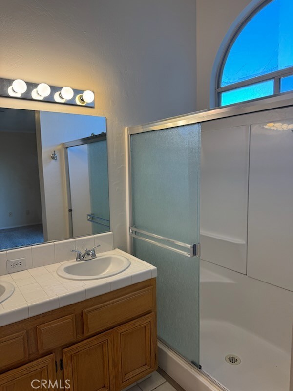 8707 Winlock Street Bakersfield, CA 93312 - Photo 14 of 18 a bathroom with a sink a mirror and a shower