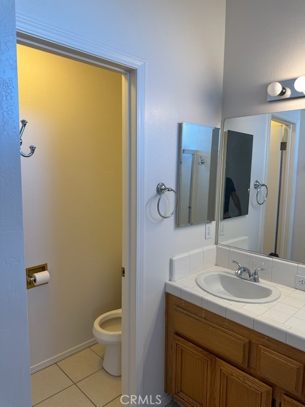 8707 Winlock Street Bakersfield, CA 93312 - Photo 15 of 18 a bathroom with a granite countertop sink toilet and mirror
