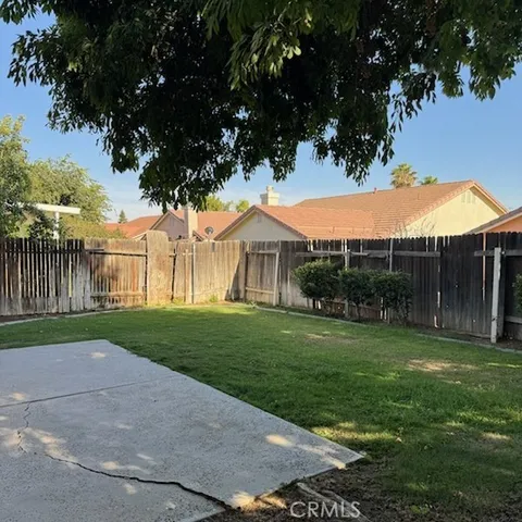 a view of a house with backyard and a tree