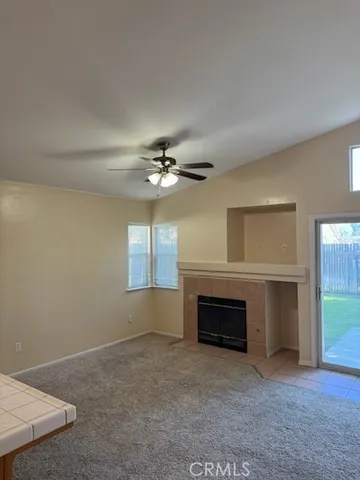 an empty room with windows and fireplace
