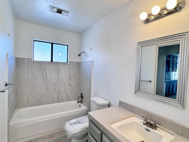 a bathroom with a sink a toilet and bathtub