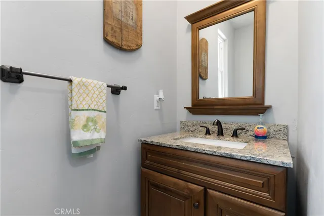 a bathroom with a granite countertop sink a large mirror and vanity