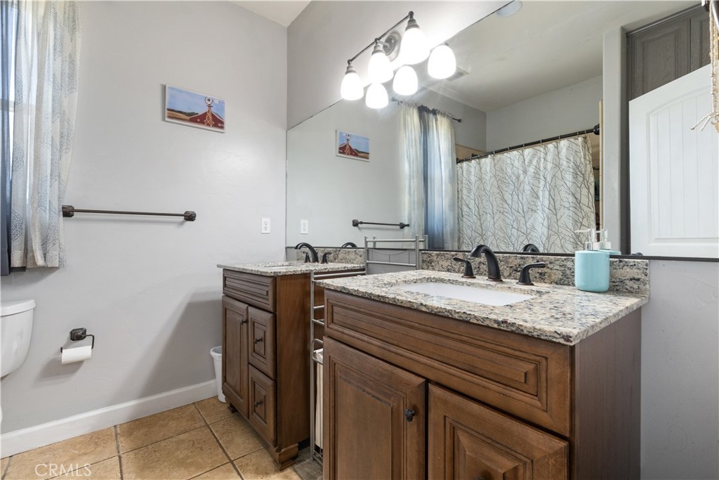 76870 Barker Road San Miguel, CA 93451 - Photo 25 of 66 a bathroom with a granite countertop sink a large mirror and vanity