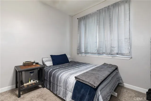 a bedroom with a bed and a painting on the wall