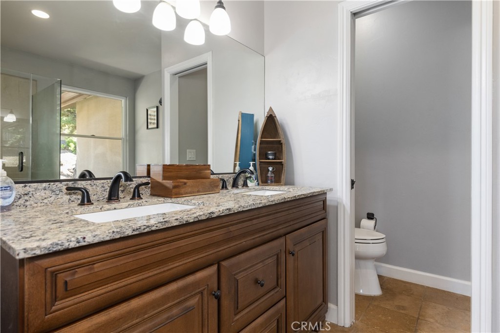76870 Barker Road San Miguel, CA 93451 - Photo 36 of 66 a bathroom with a granite countertop sink a toilet and a mirror