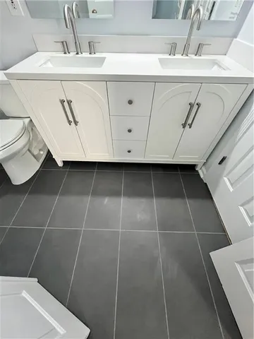 a bathroom with a sink a toilet and a mirror