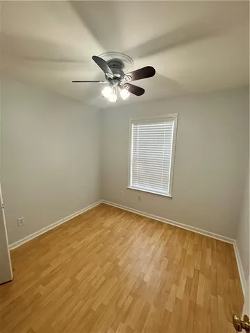 a view of an empty room and chandelier fan