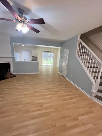 a view of an empty room with window and wooden floor