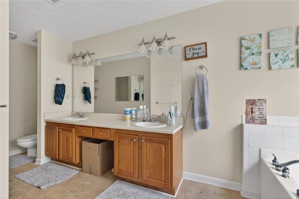 120 Norman Road Covington, GA 30014 - Photo 23 of 31 a spacious bathroom with a double vanity sink toilet mirror and bathtub