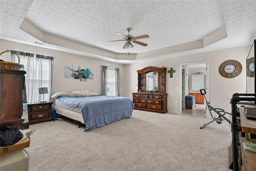 120 Norman Road Covington, GA 30014 - Photo 25 of 31 a spacious bedroom with a bed a dresser and a chandelier