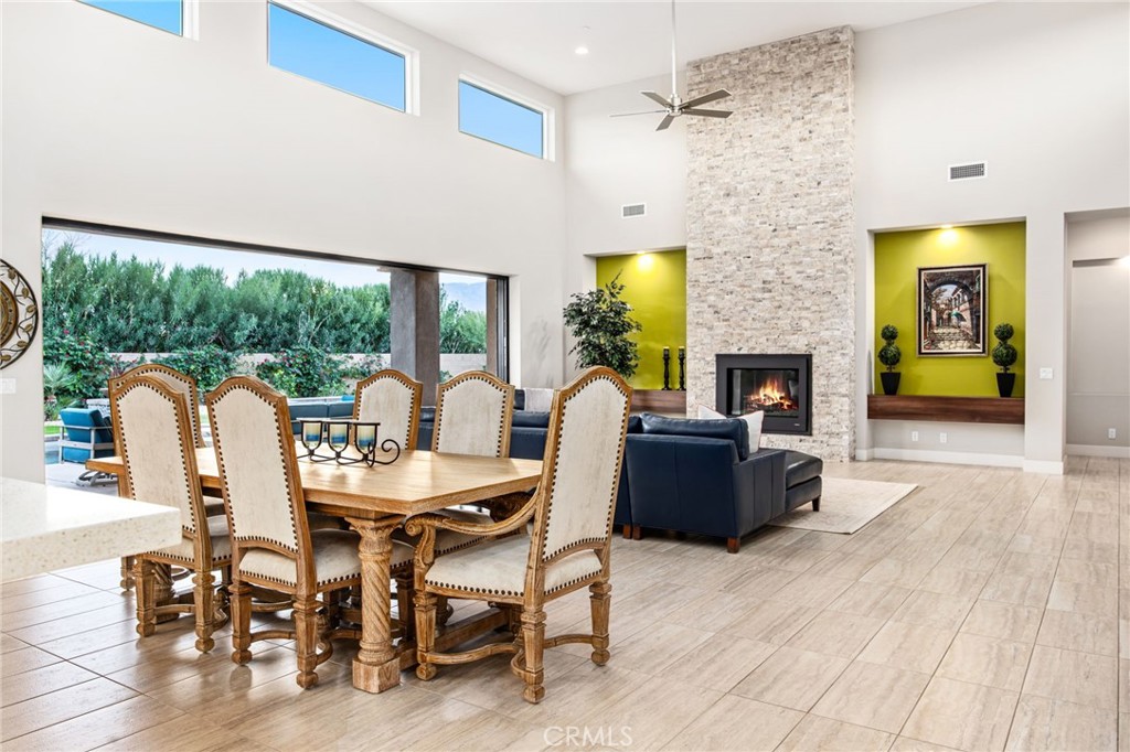 15 Via Montagna Rancho Mirage, CA 92270 - Photo 30 of 75 a living room with furniture a fireplace and a floor to ceiling window