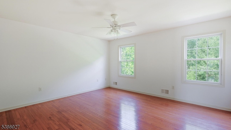 16 Riga Court Scotch Plains, NJ 07076 - Photo 22 of 33 an empty room with wooden floor windows and fan
