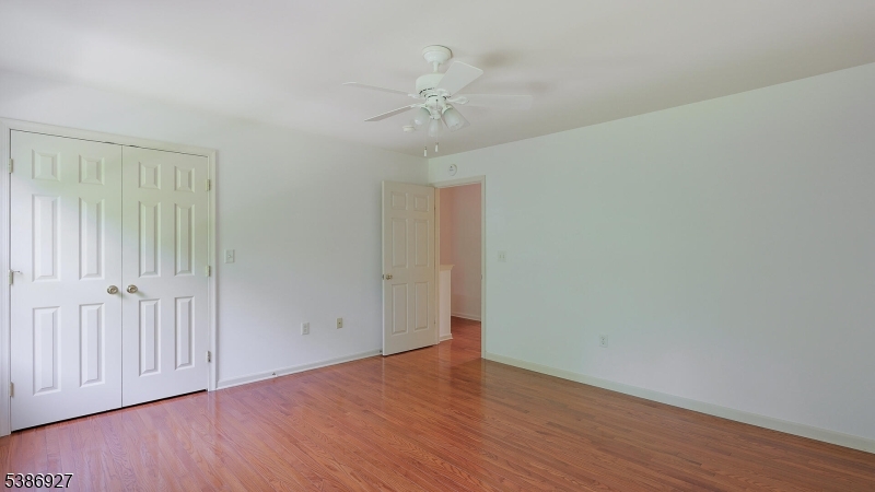 16 Riga Court Scotch Plains, NJ 07076 - Photo 23 of 33 a view of an empty room with wooden floor and a ceiling fan