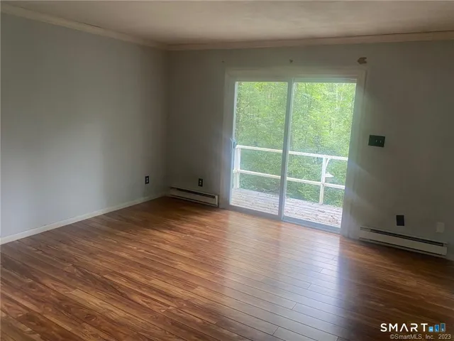 a view of a room with wooden floor and window