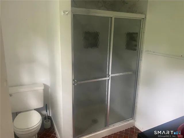 a bathroom with a toilet and a shower