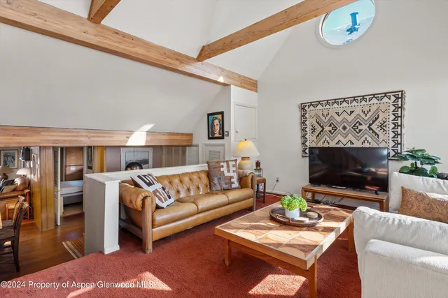 a living room with furniture a rug and a flat screen tv