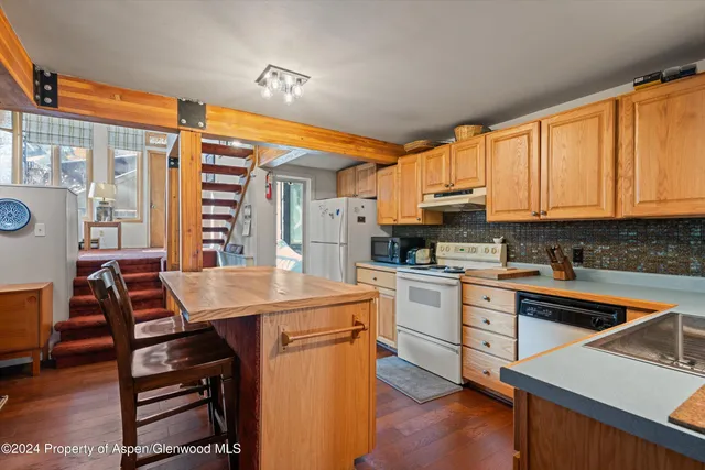 a kitchen with stainless steel appliances kitchen island granite countertop a stove a sink and a refrigerator