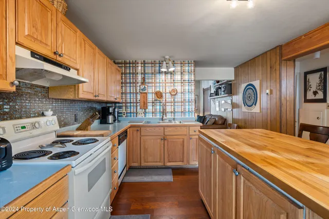 a kitchen with granite countertop a sink stove and cabinets