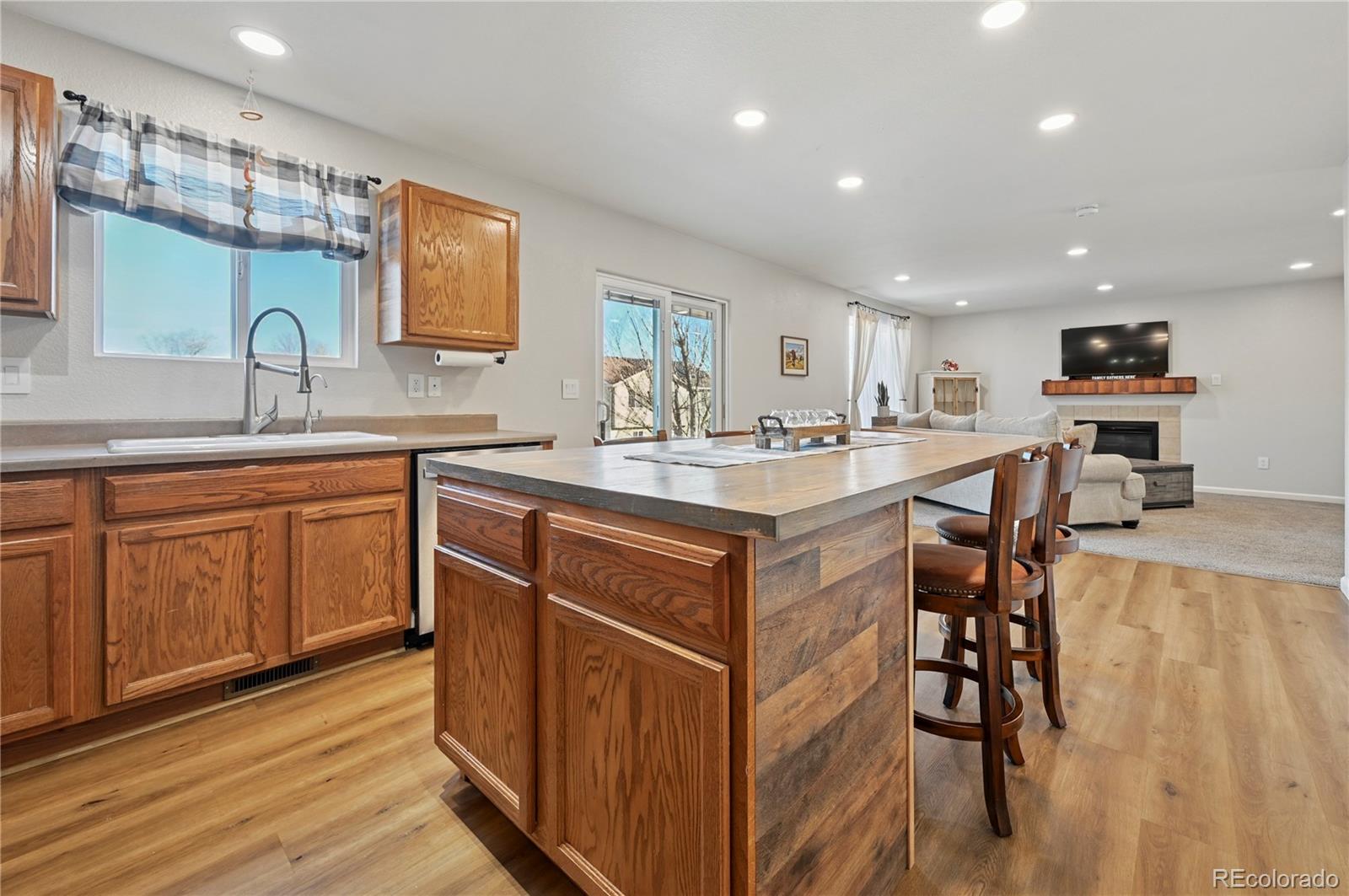 795 Winebrook Way Fountain, CO 80817 - Photo 11 of 41 a kitchen with a sink stove cabinets and wooden floor