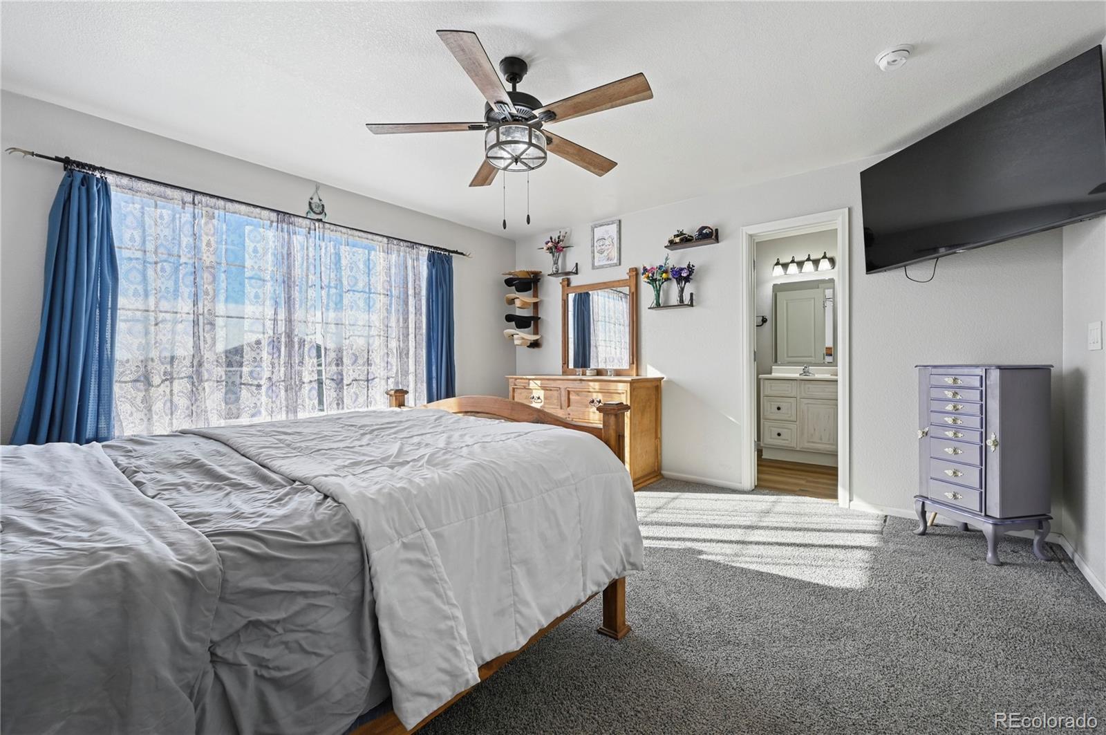795 Winebrook Way Fountain, CO 80817 - Photo 18 of 41 a spacious bedroom with a bed and a flat screen tv