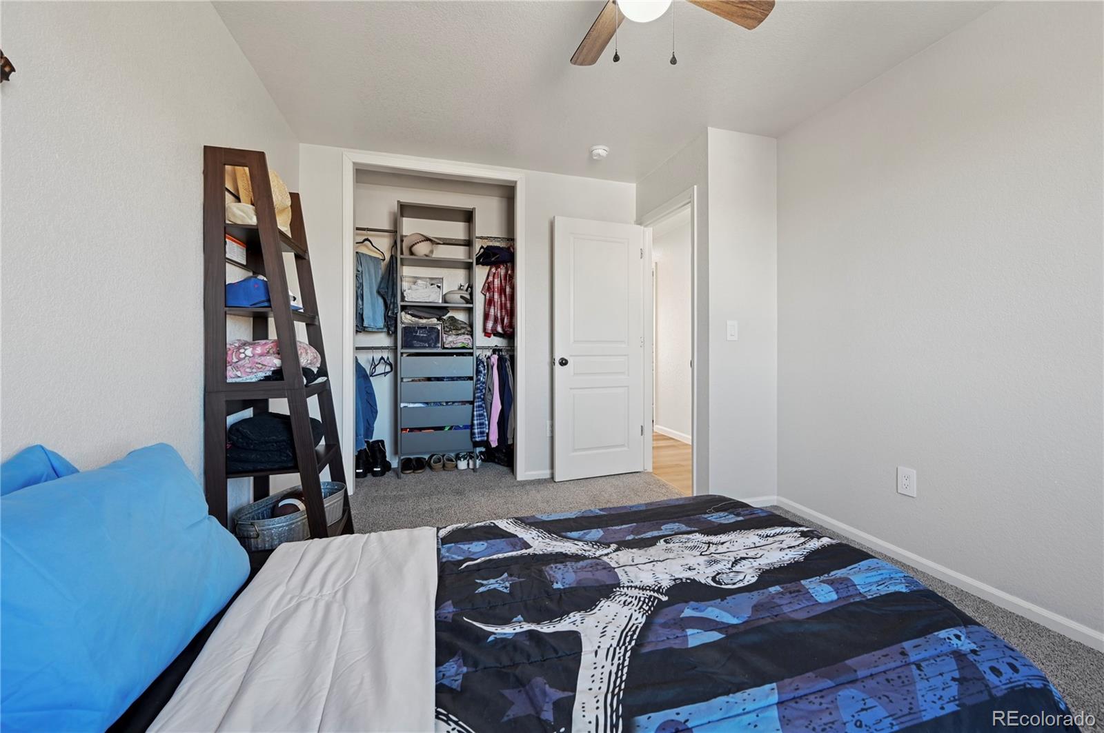 795 Winebrook Way Fountain, CO 80817 - Photo 27 of 41 a bedroom with bed and a walk in closet