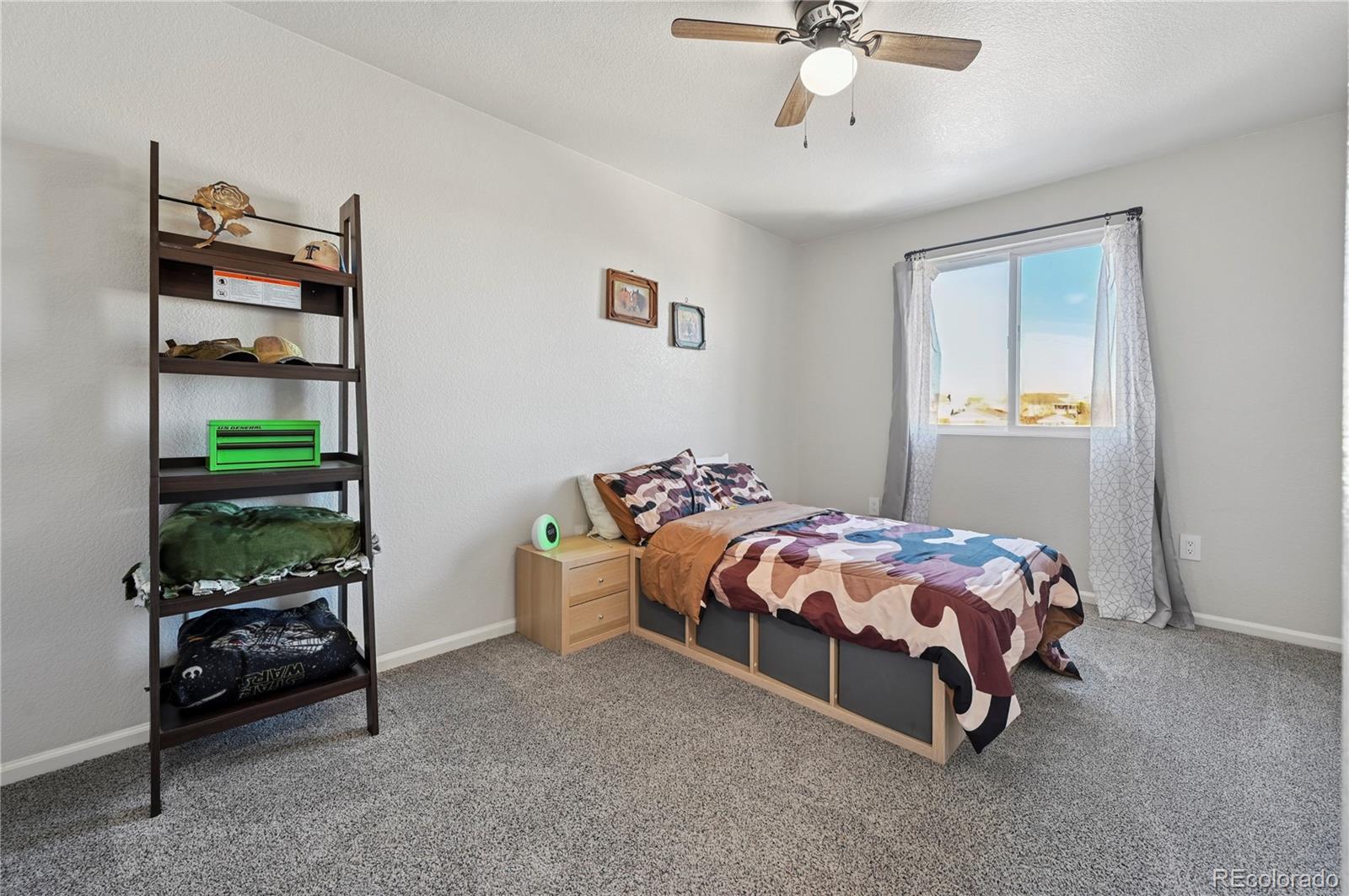 795 Winebrook Way Fountain, CO 80817 - Photo 29 of 41 a bedroom with a bed and a chandelier