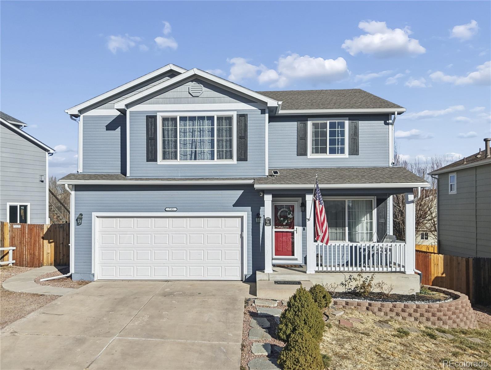 795 Winebrook Way Fountain, CO 80817 - Photo 3 of 41 a front view of a house with a yard and garage