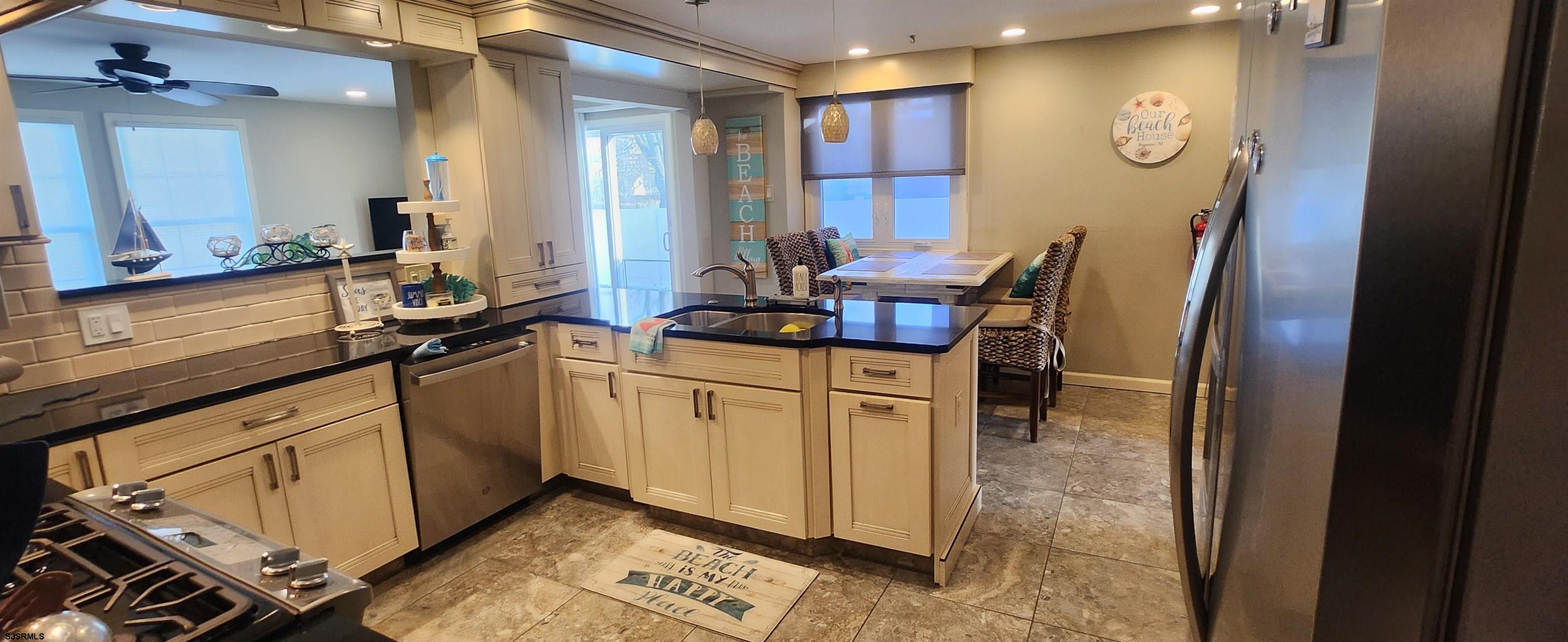 5217 Harbor Beach Boulevard, Unit SEA POINT Brigantine, NJ 08203 - Photo 22 of 38 a kitchen with stainless steel appliances granite countertop a sink a stove a dining table and chairs