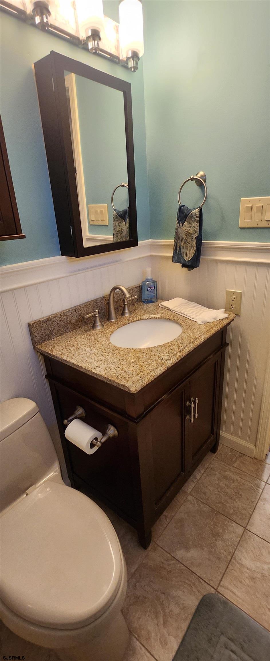 5217 Harbor Beach Boulevard, Unit SEA POINT Brigantine, NJ 08203 - Photo 35 of 38 a bathroom with a granite countertop sink and a mirror