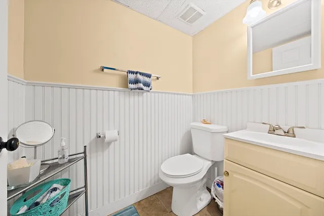 a bathroom with a toilet sink vanity and mirror