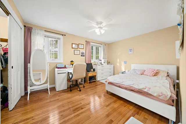 a bedroom with a bed wooden floor and a window