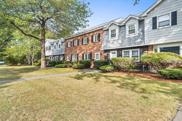 a front view of a house with a yard and outdoor seating