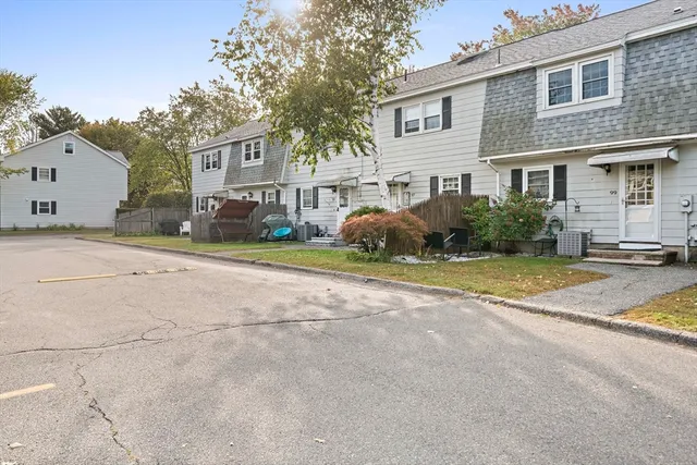 a view of a white house with a large windows next to a road