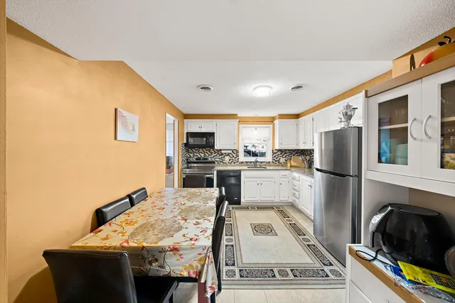 a kitchen with stainless steel appliances granite countertop a refrigerator stove top oven and sink
