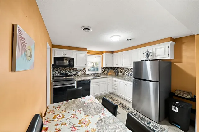 a kitchen with a refrigerator stainless steel appliances wooden floor and cabinets