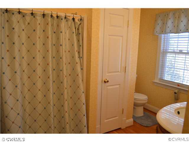 4706 Twin Cedars Road Chester, VA 23831 - Photo 11 of 24 a bathroom with a toilet and a shower curtain